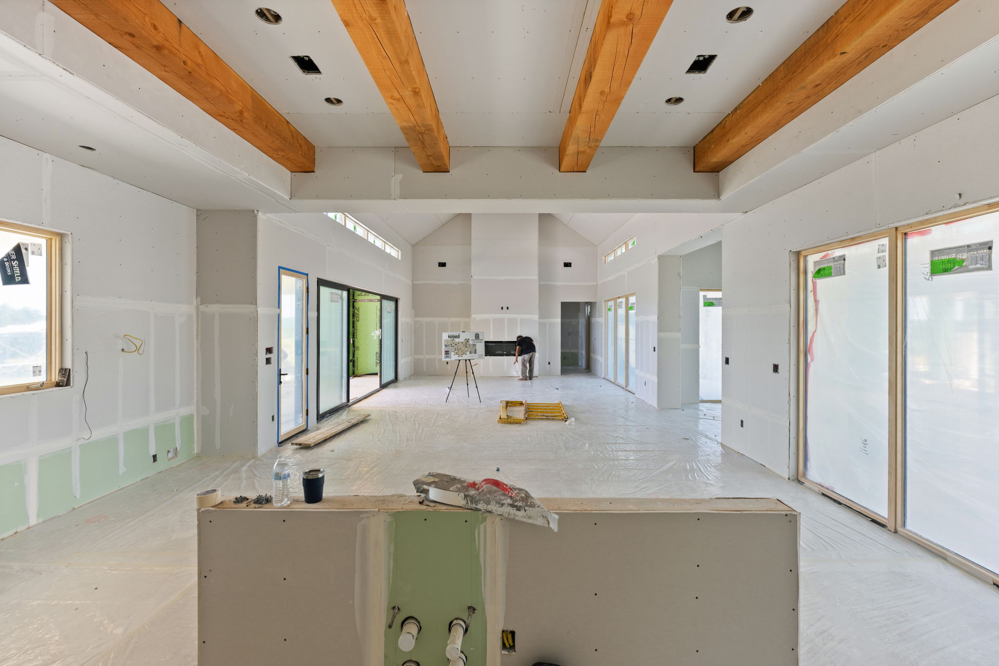 The open great room at Beautyberry House with exposed timber beams and broad glass doors