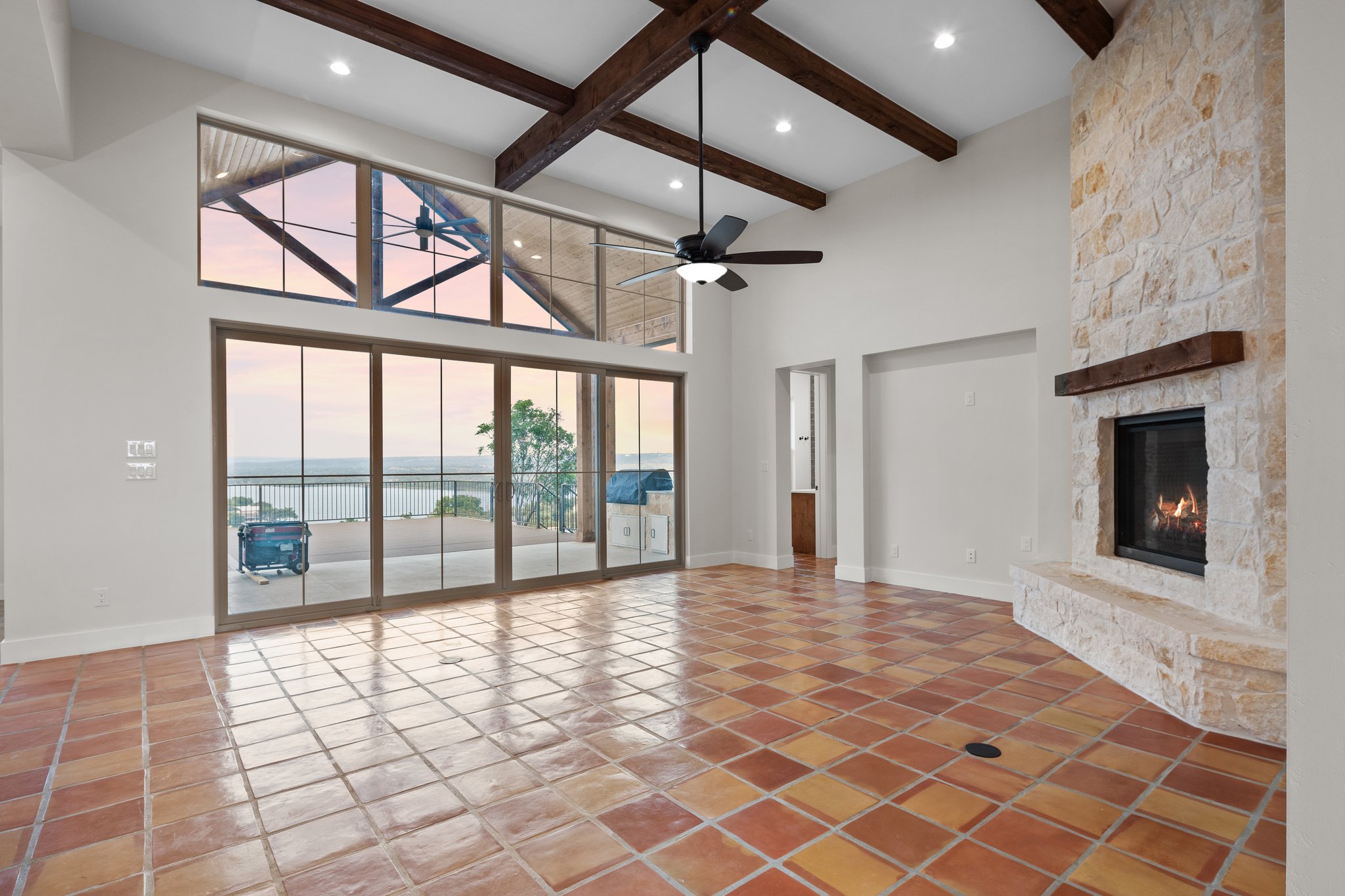 Ridge House great room with timber beams and a panoramic lake view