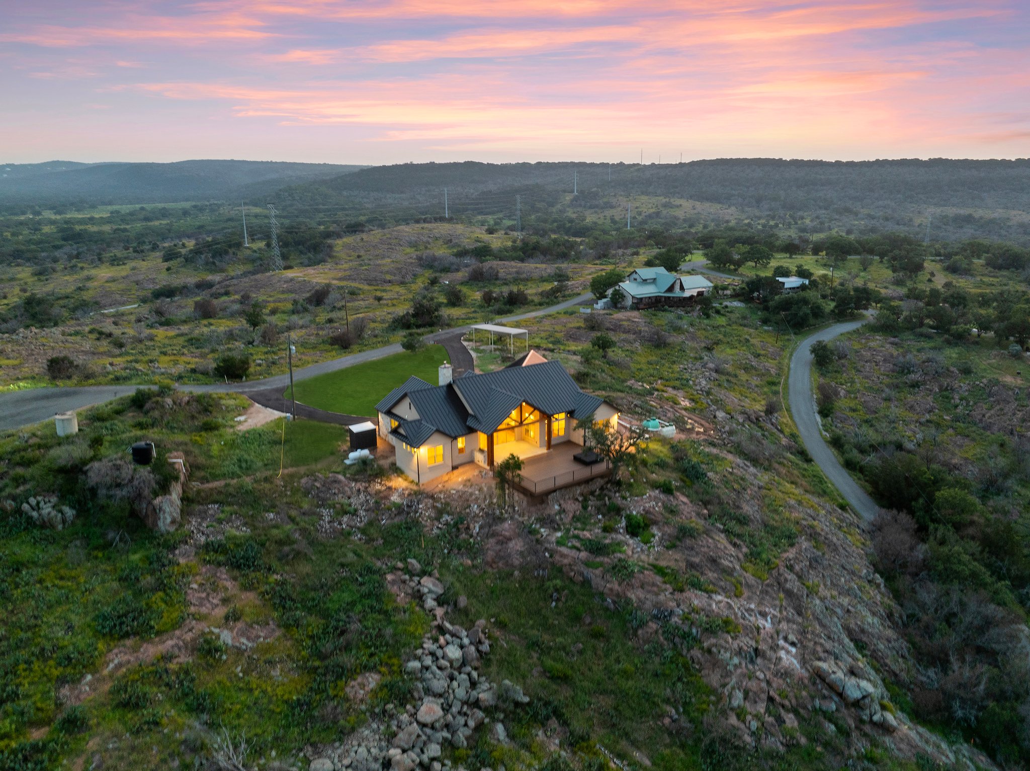 Ridge House glowing on its Hill Country ridgeline